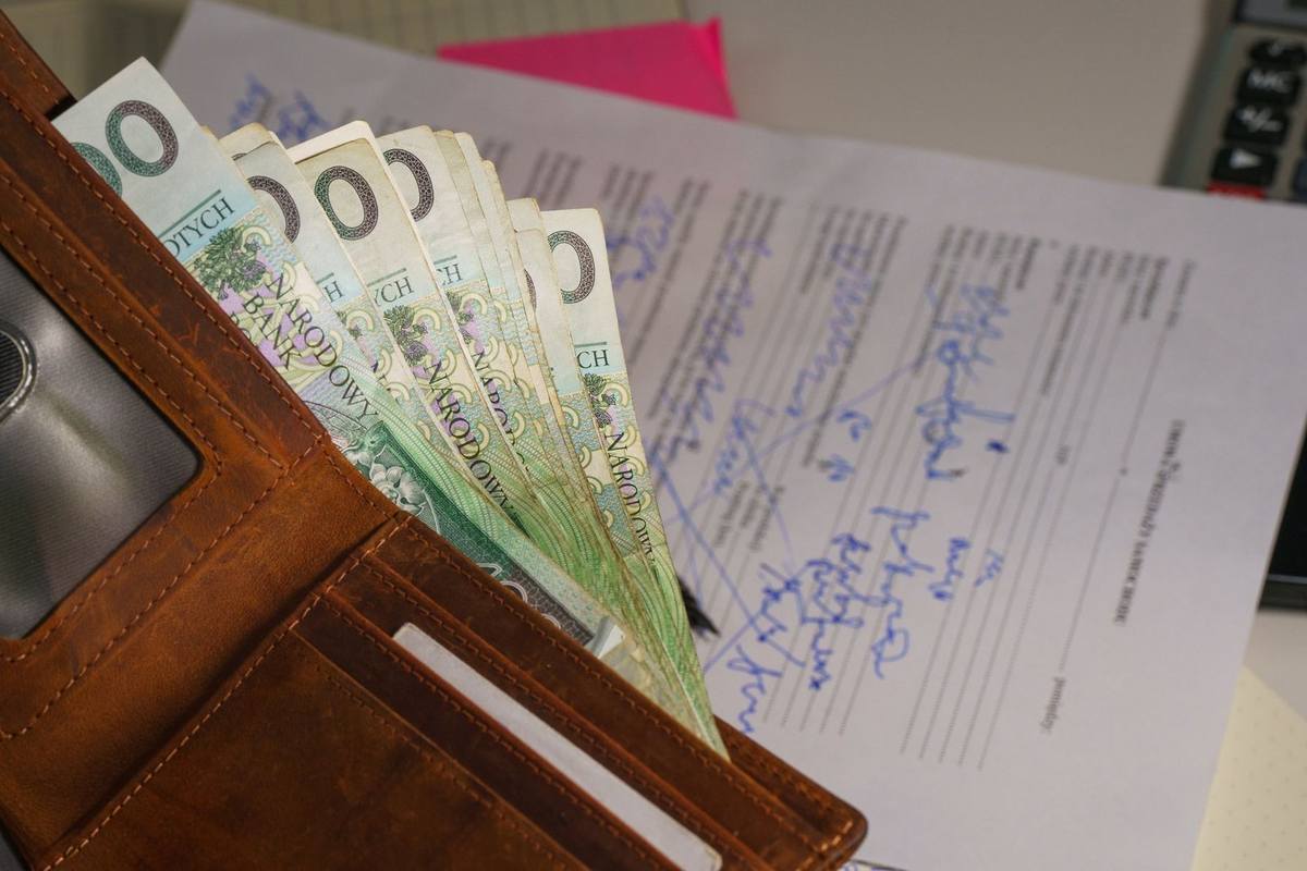 Portefeuille ouvert avec des billets de 20 euros et des papiers manuscrits