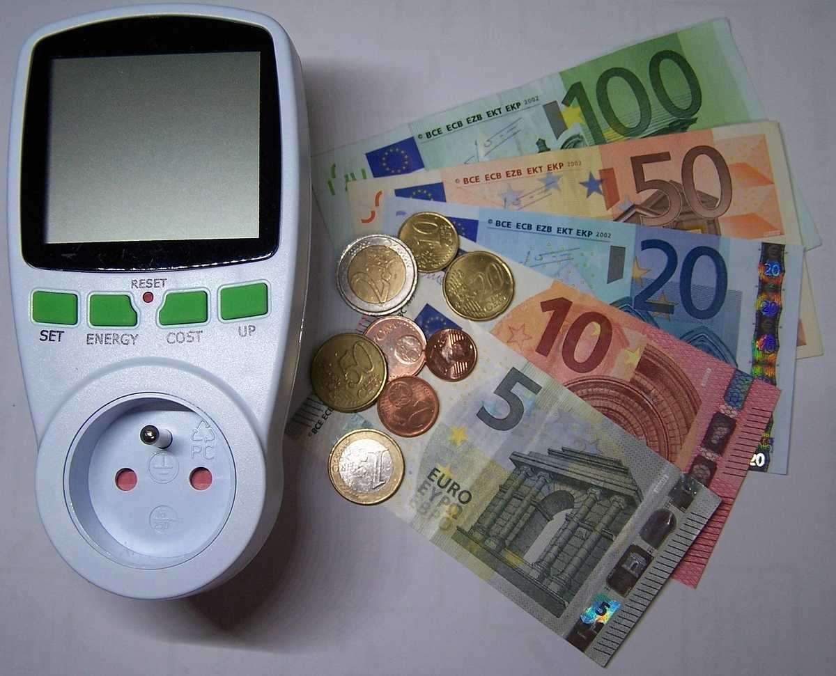 Compteur électrique, pièces et billets d'euro sur fond neutre Compteur électrique, pièces et billets d'euro sur fond neutre