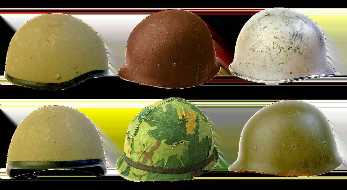 Six casques militaires en différentes couleurs et motifs, exposés sur fond blanc Six casques militaires en différentes couleurs et motifs, exposés sur fond blanc